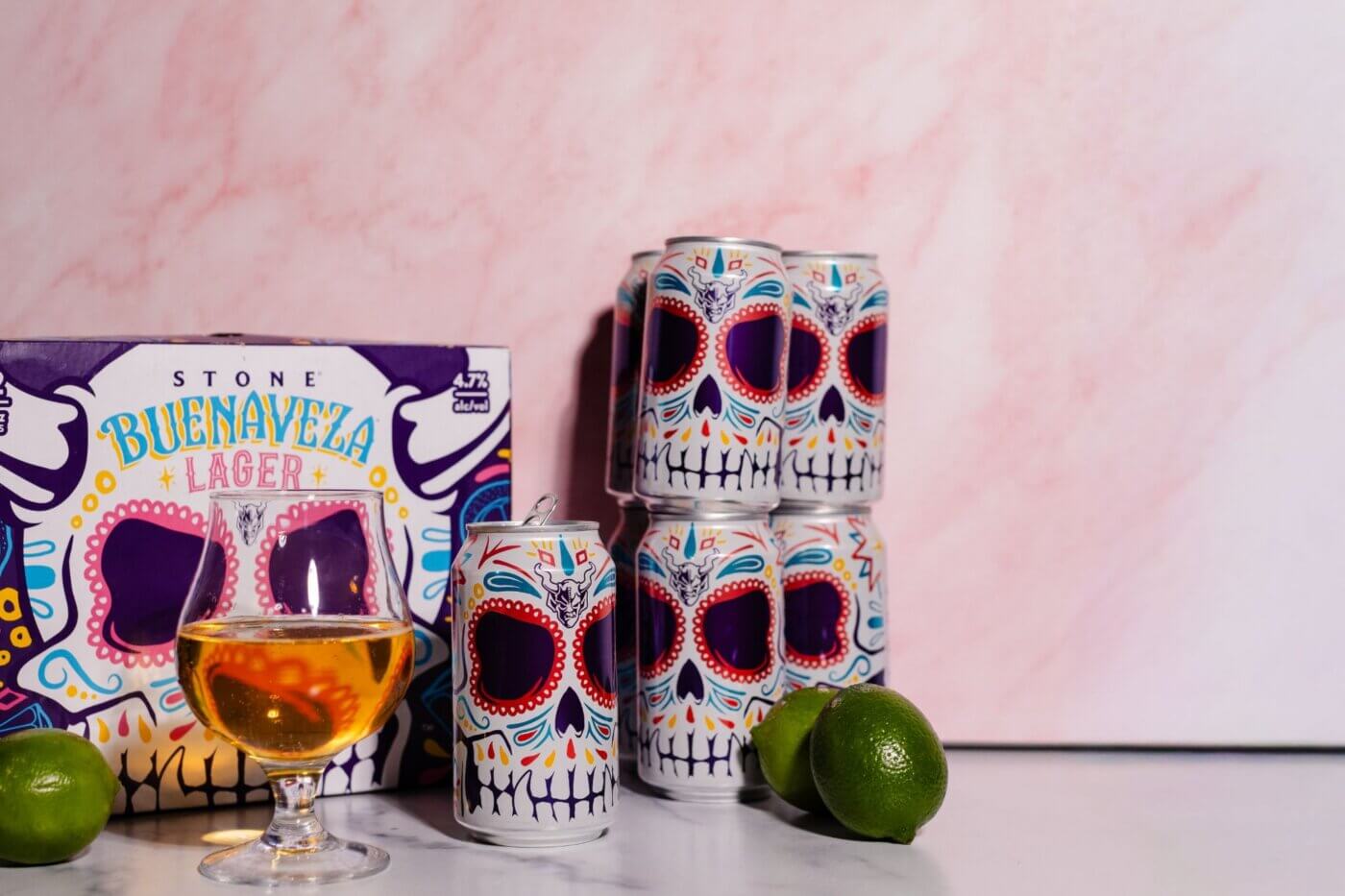 Box of Stone Buenaveza with cans sitting next to it and beer glass full of beer