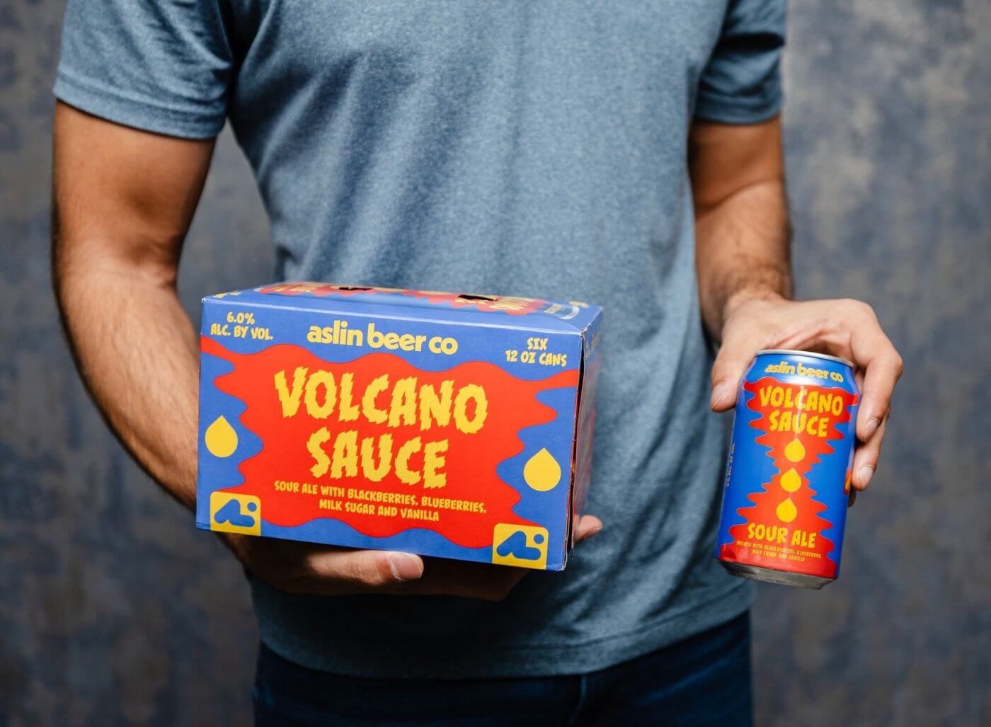Man holding Volcano Sauce Beer Box and Can